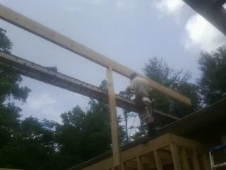 Carpenter setting a ridge beam over a new addition frame — Ice Dam Removal by Roofing Brothers in North Hills