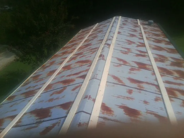 Rusted metal roof panels with new wood purlins before replacement — Storm Damage Roof Repair in North Hills by Roofing Brothers