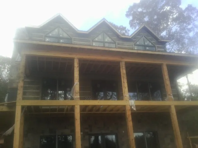 Dormers and porch framing on a large log home under construction — Roof Coating work by our crew in North Hills